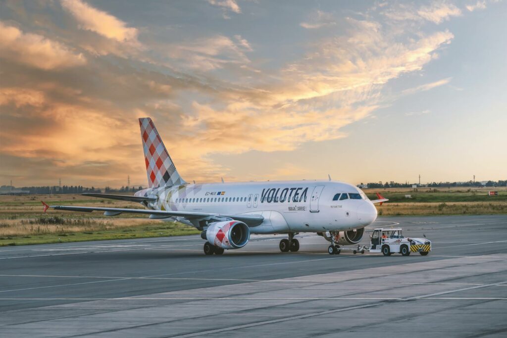 Volotea airplane on airport tarmac during sunset, showcasing aviation and travel.