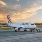 Volotea airplane on airport tarmac during sunset, showcasing aviation and travel.