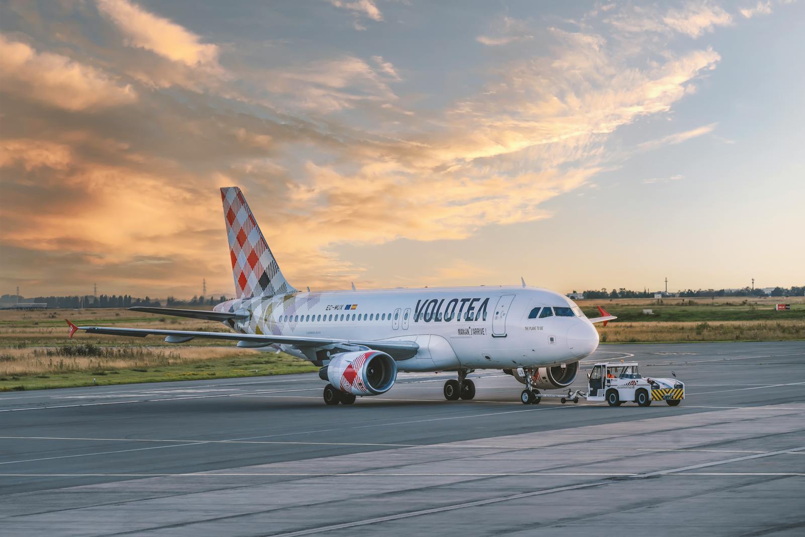Volotea airplane on airport tarmac during sunset, showcasing aviation and travel.