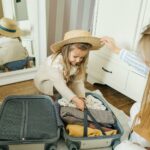 A mother and daughter pack a suitcase for a summer vacation, creating joyful memories.
